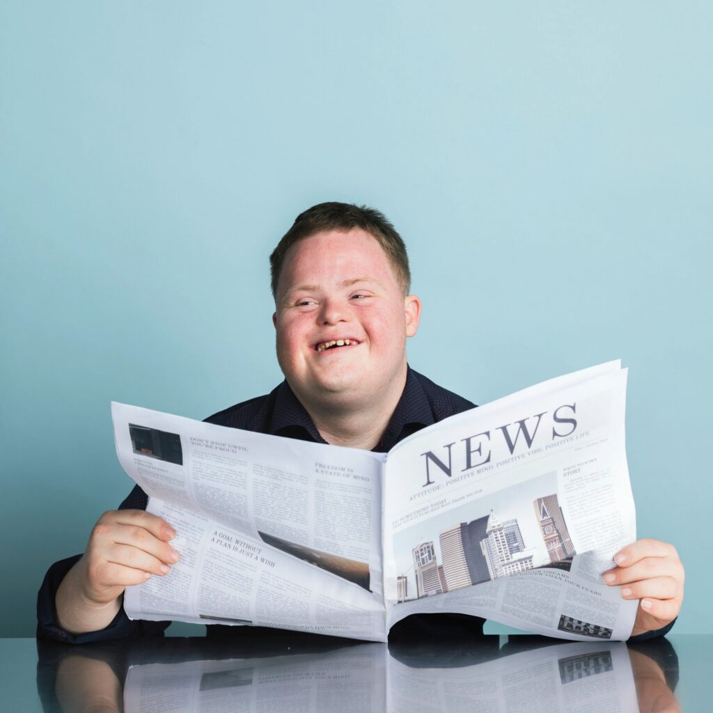 Boy with down syndrome reading a newspaper during the coronavirus pandemic